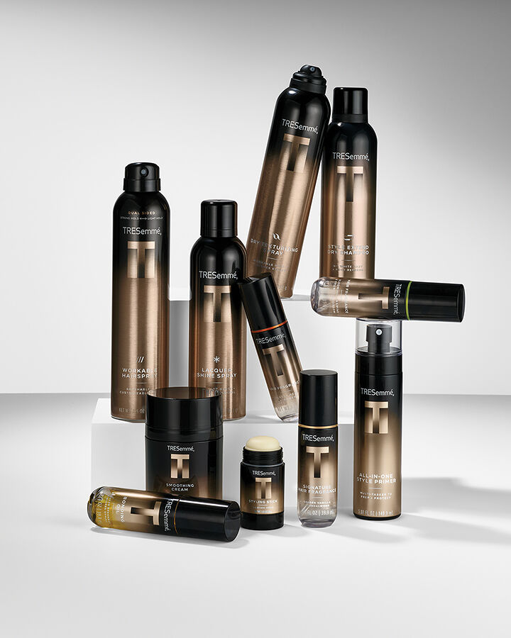 A display of all the reliable and hardworking styling products from the TRESemmé A-List Collection in the gold and black bottles, which can be used to get professional Runway-approved hairstyles at home. 