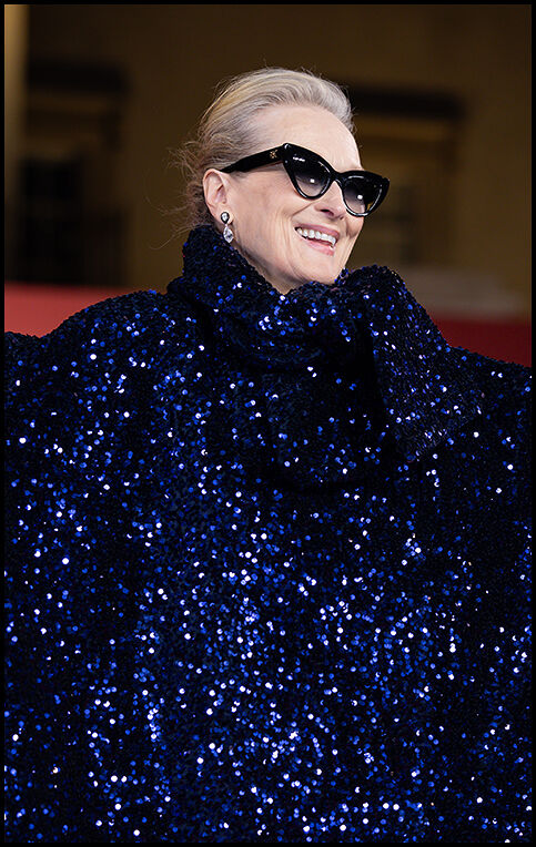 Close‑up of Meryl Streep smiling and looking off into the distance, highlighting the navy sequins of her dress.