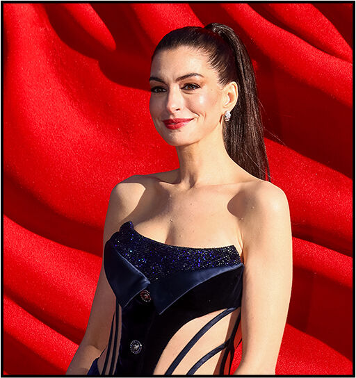 Close‑up of Anne Hathaway with a slicked‑back high ponytail, highlighting the sparkling details on the top of her dress.