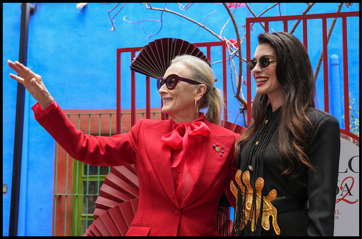 Meryl Streep waves while standing next to Anne Hathaway in Mexico City.