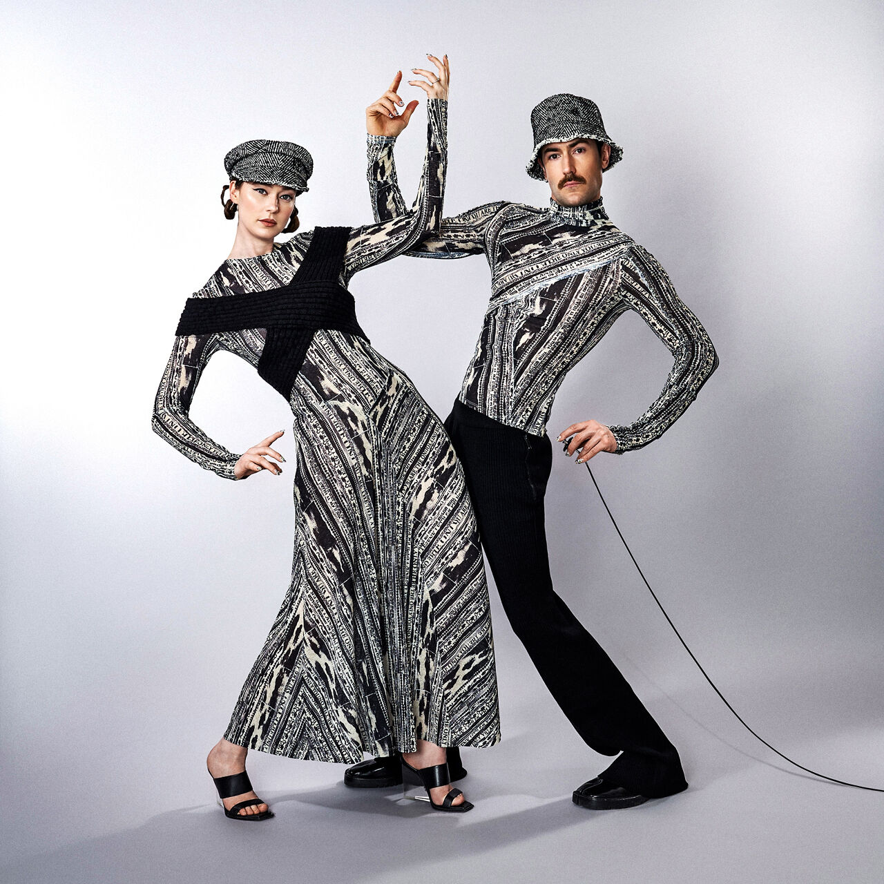 The Young Emperors coordinate and collaborate in clothes made from the same black and white print fabric as well as hats constructed from the same material.