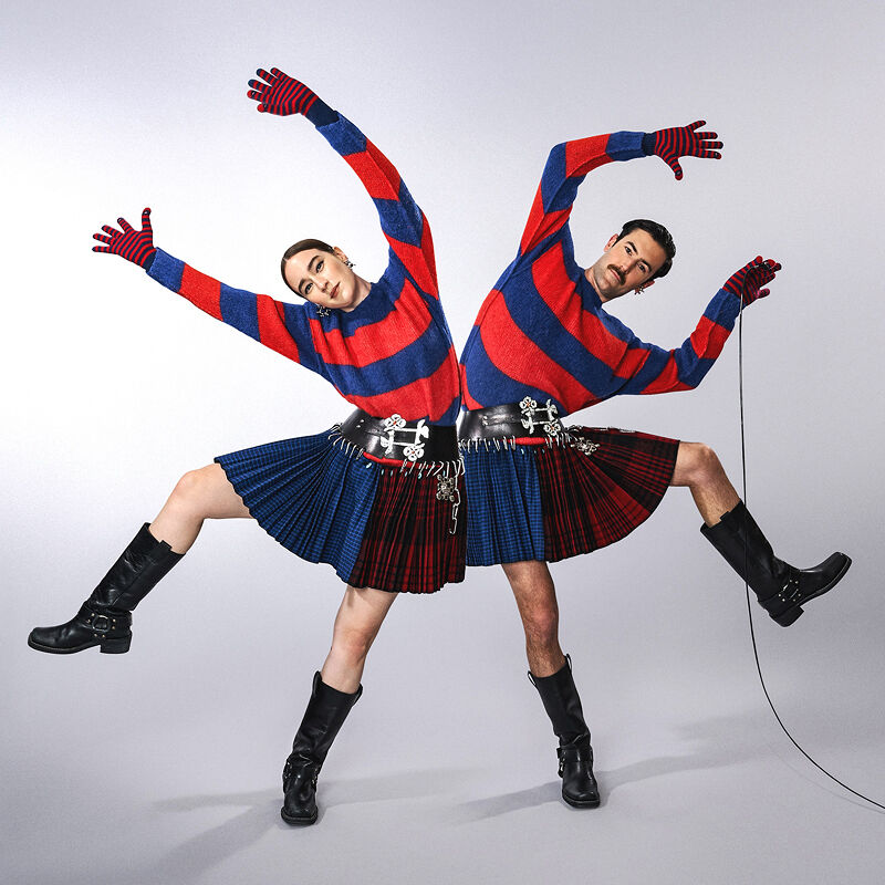 The Young Emperors look like a mirror image of each other in kilt-like skirts, striped red and blue sweaters and chunky boots.