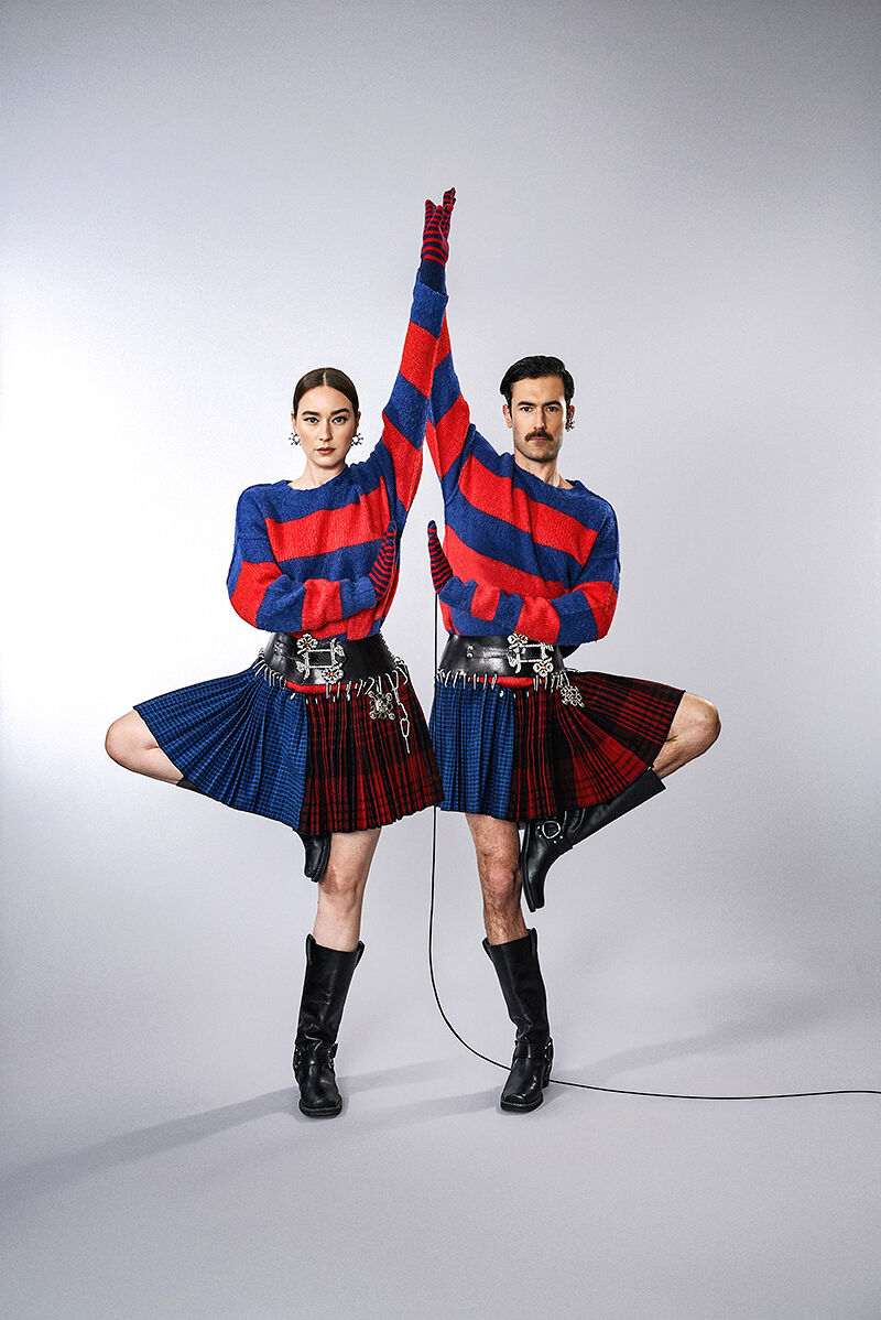The artistic power couple known as Young Emperors twin in striped sweaters, pleated skirts, wide belts with intricate floral buckles, gloves and calf-high motorcycle boots. Nelson Tiberghien even wears one of the same earrings as Isabelle Chaput.