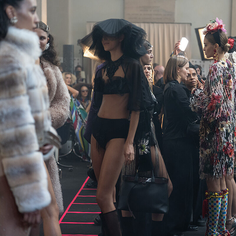 Models in spring’s finest threads milling around backstage as their looks get scrutinized and touched up by eagle-eyed staff members moments before the Runway show at Milan Fashion Week begins.