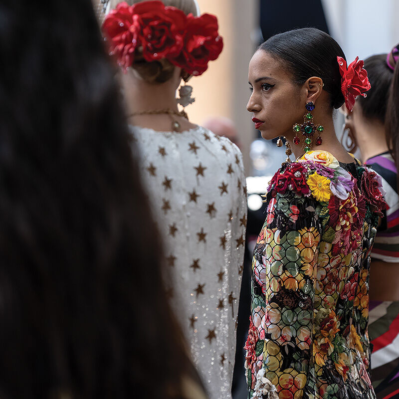 Models dressed in flower, star and Pucci-esque prints line up backstage to get the final once-over by Runway Milan Fashion Week show staff befor heading through the curtain and onto the runway.