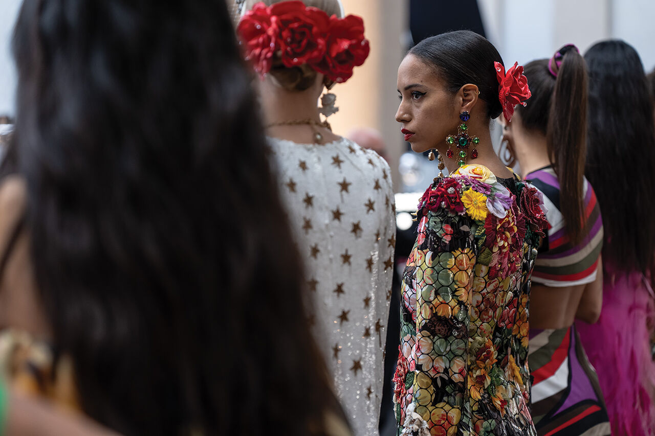 Models dressed in flower, star and Pucci-esque prints line up backstage to get the final once-over by Runway Milan Fashion Week show staff befor heading through the curtain and onto the runway.