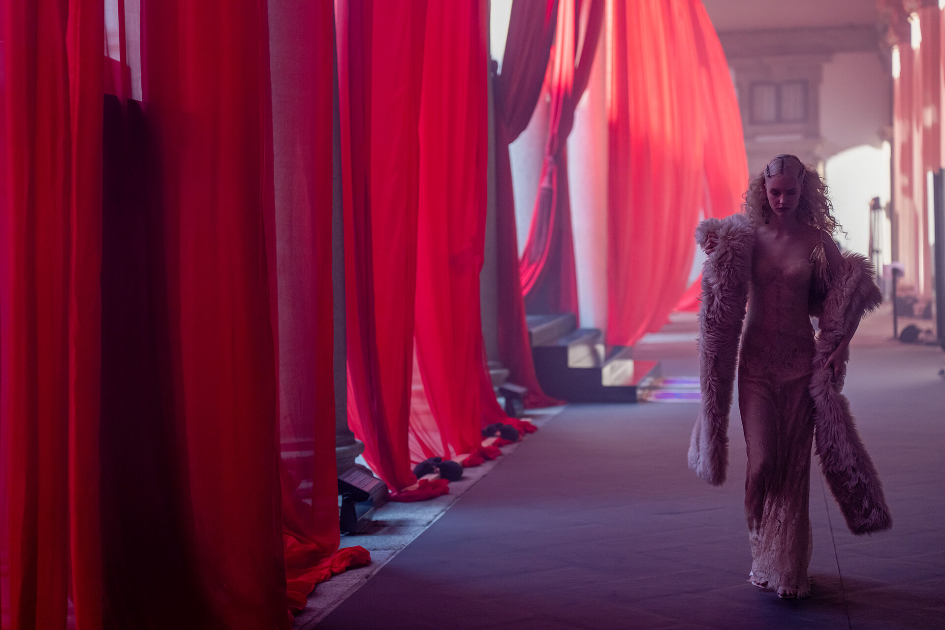 Minutes before the Runway show at Milan Fashion Week begins, a model with a fur boa takes a quiet moment in the dark to steel herself for the stressful catwalk ahead.