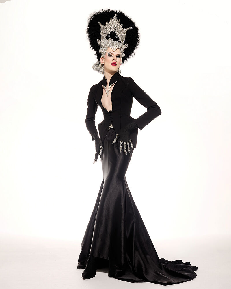 Drag performer Utica Queen (née Ethan Mundt) strikes a rebellious pose in a high-glam black corseted dress, tall jeweled headpiece made in collaboration with Edward Smith and shimmery statement gloves.