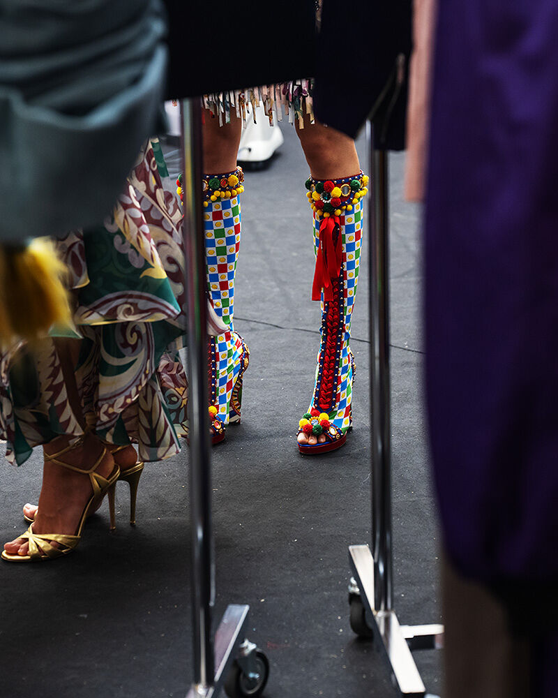 Models wearing a variety of brightly colored, patterned shoes.