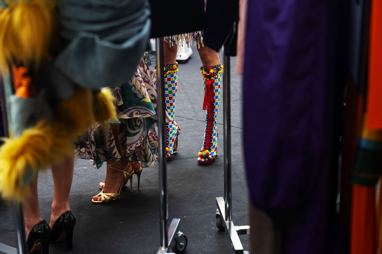 Models wearing a variety of brightly colored, patterned shoes.