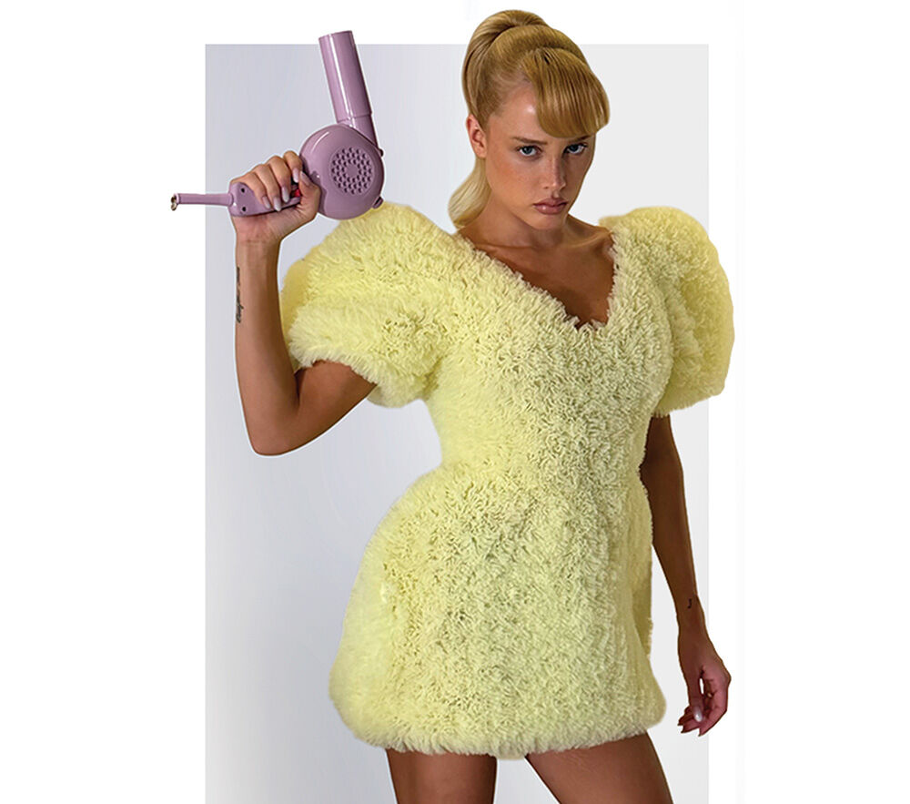 Quirky fashion influencer and Brazilian model Malu Borges in a puffy yellow mini dress with her hairdryer-shaped purse.