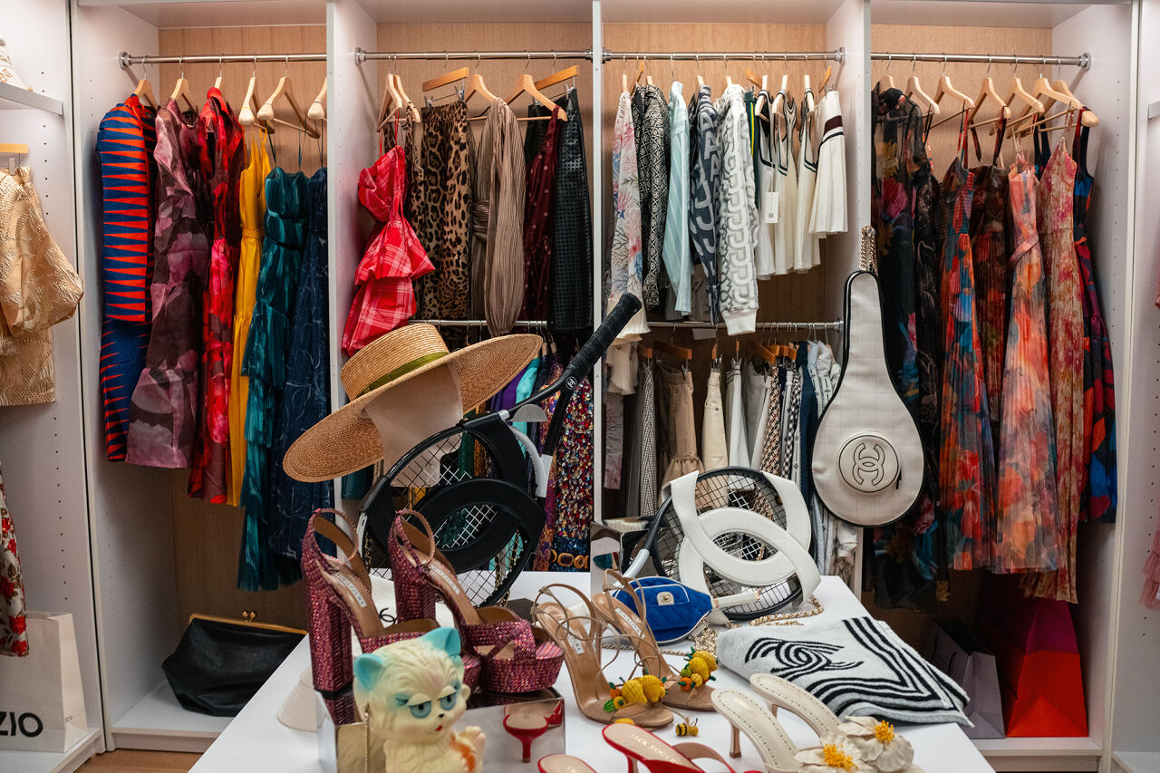 Racks of clothes organized by style and color await the arrival of editor Miranda Priestly but they will have to compete with Chanel’s chic line of tennis accessories and flashy stilettos for her attention.