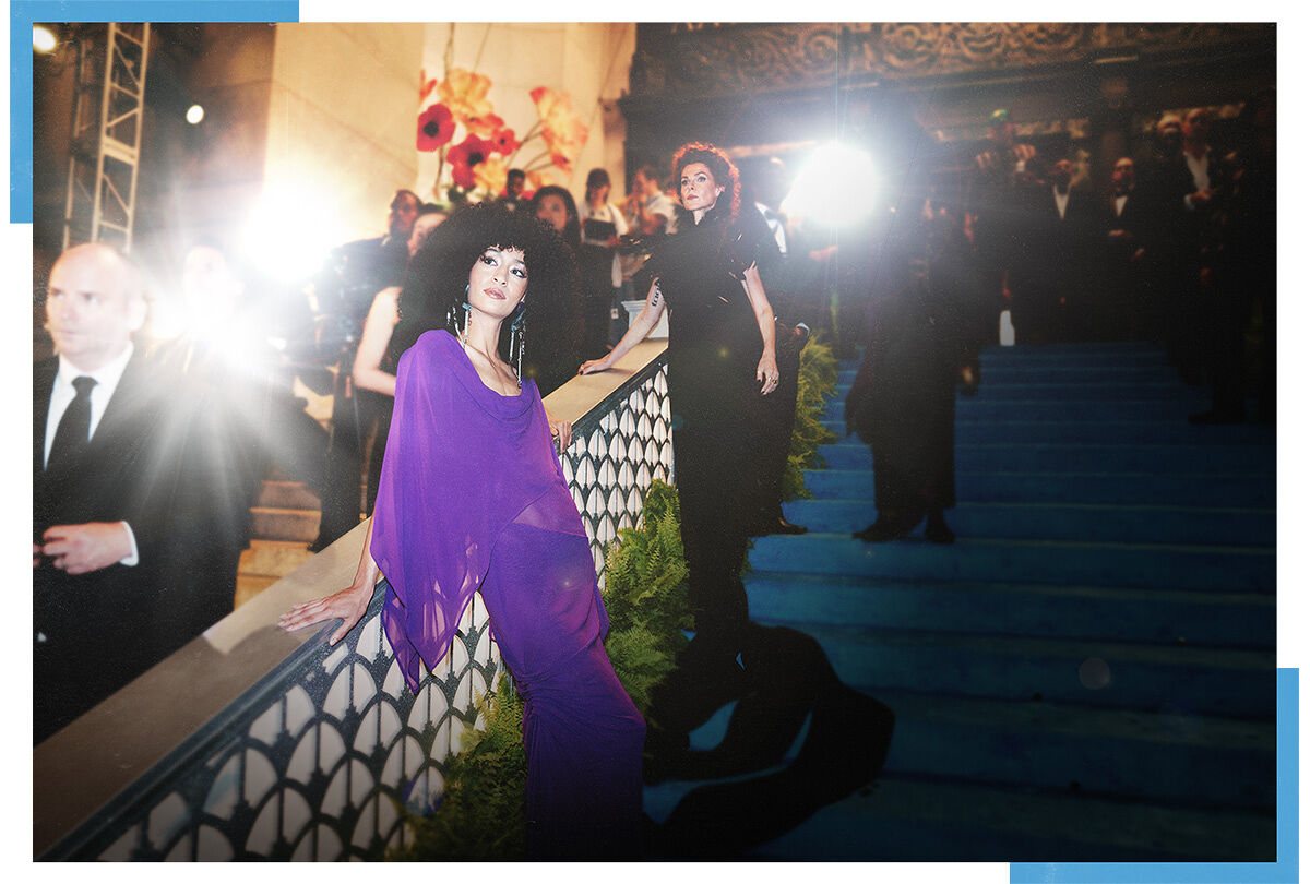 Two models — one in a gossamer gown inspired by an orchid and the other in a inky feather floor-length number representing the black dahlia — embody the Spring Florals theme during arrivals at the Runway Gala.