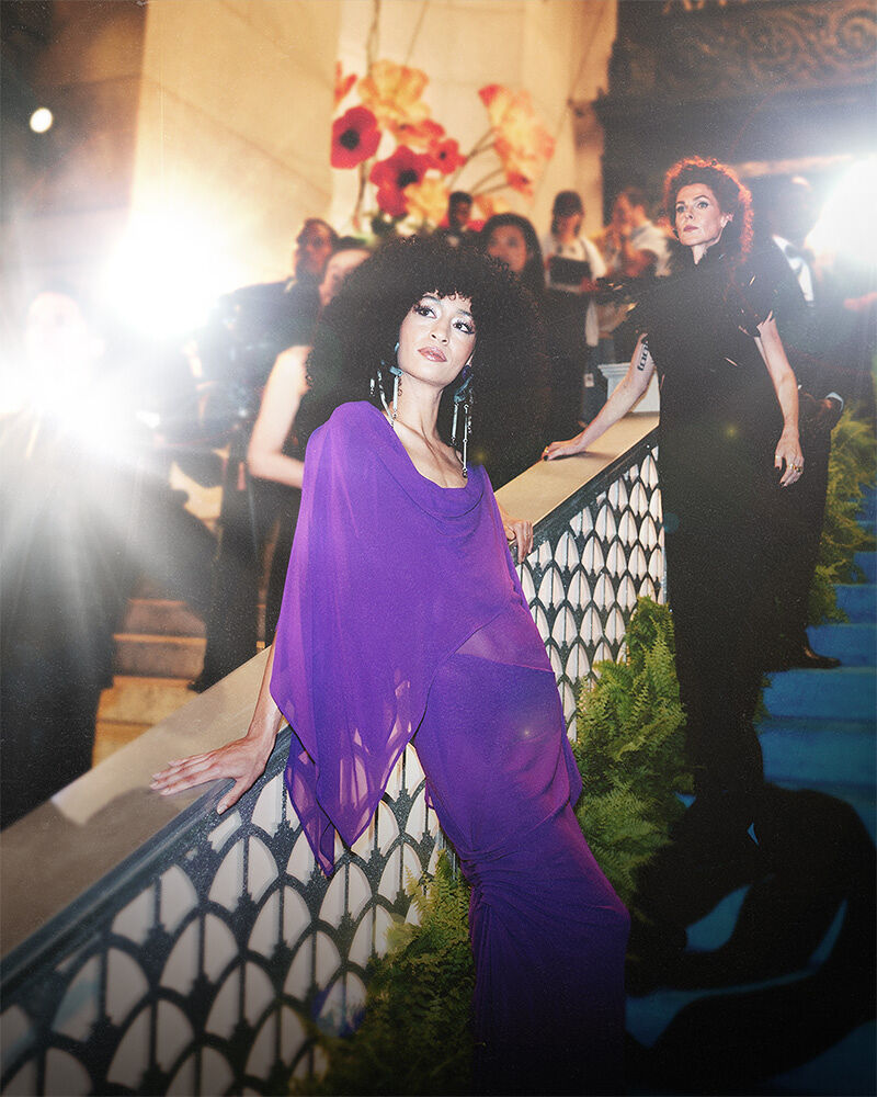 Two models — one in a gossamer gown inspired by an orchid and the other in a inky feather floor-length number representing the black dahlia — embody the Spring Florals theme during arrivals at the Runway Gala.