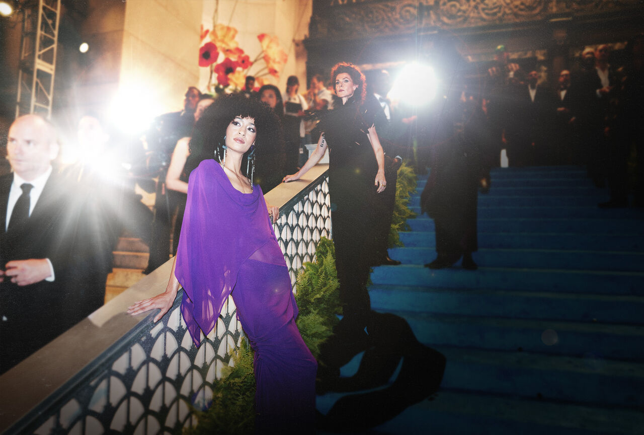 Two models — one in a gossamer gown inspired by an orchid and the other in a inky feather floor-length number representing the black dahlia — embody the Spring Florals theme during arrivals at the Runway Gala.