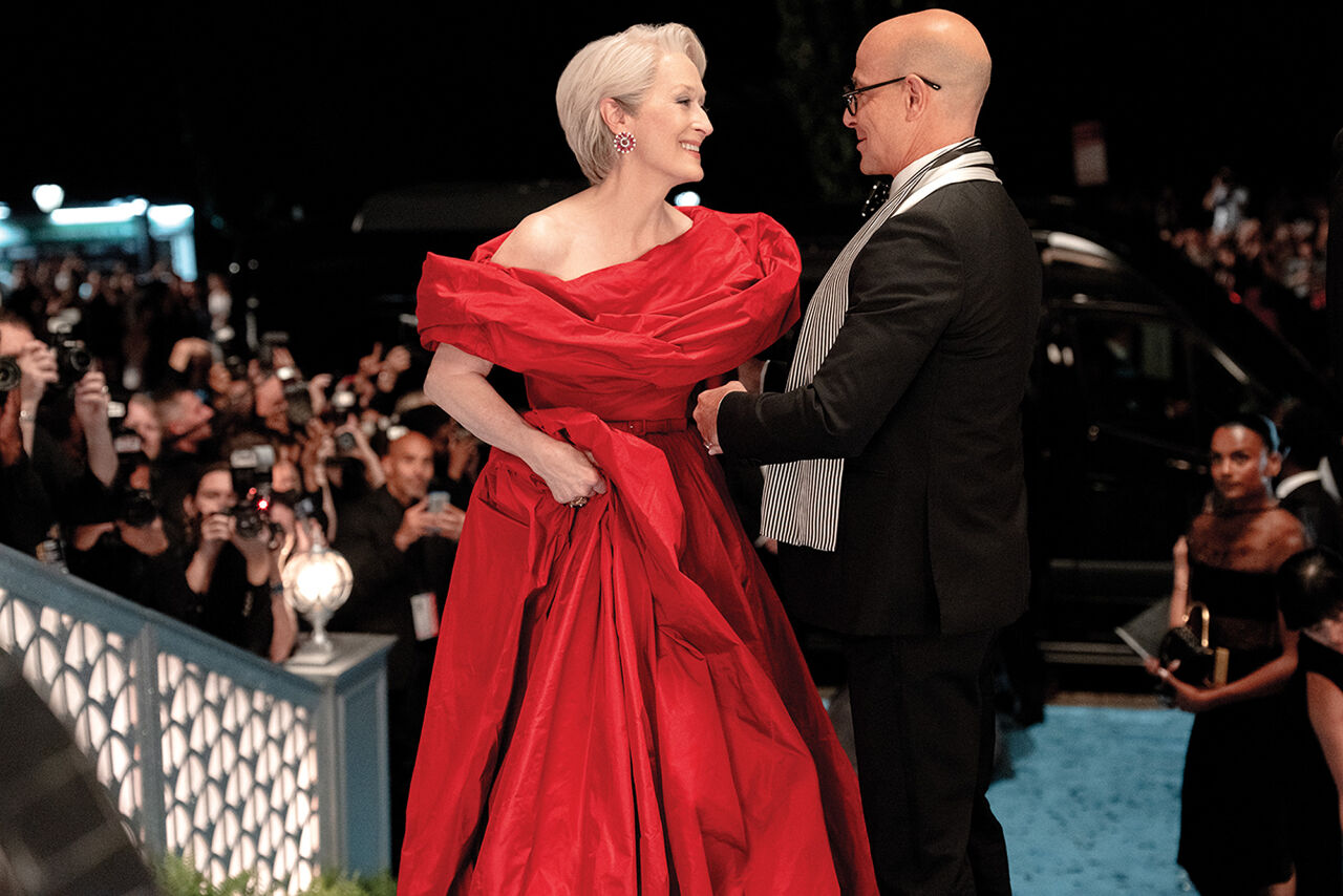 Nigel Kipling, deputy editor of Runway, welcomes his boss Miranda Priestly, the event’s host, and her devilishly glamorous red-hot gown to the cerulean carpet at the annual Runway Gala.