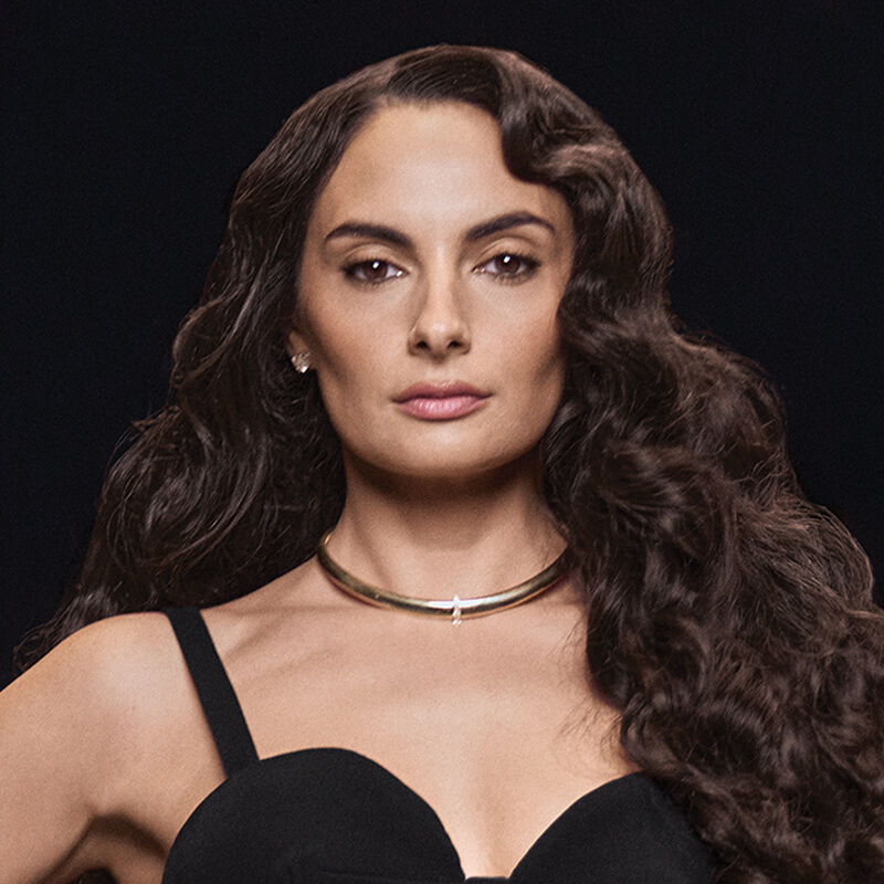 A brunette model’s brilliant and bouncy romantic curls, paired perfectly with her black bustier-esque gown.