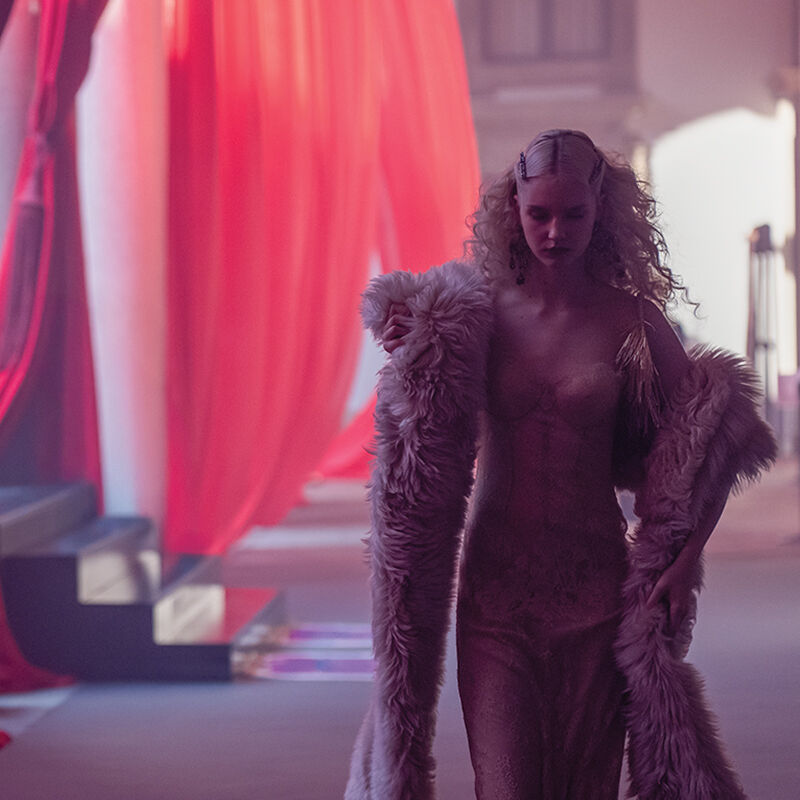 Minutes before the Runway show at Milan Fashion Week begins, a model with a fur boa takes a quiet moment in the dark to steel herself for the stressful catwalk ahead.