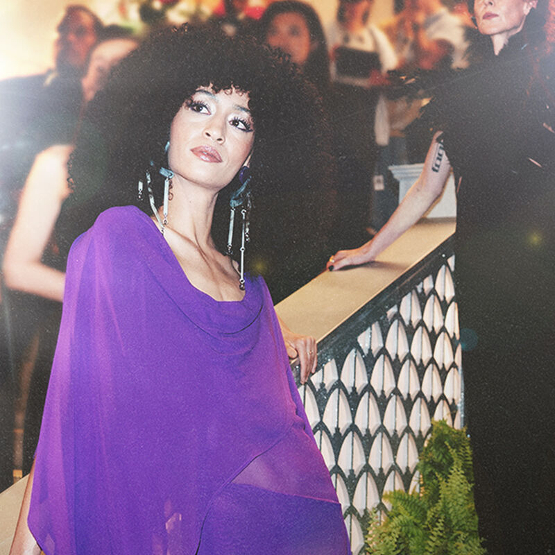 Two models — one in a gossamer gown inspired by an orchid and the other in a inky feather floor-length number representing the black dahlia — embody the Spring Florals theme during arrivals at the Runway Gala.