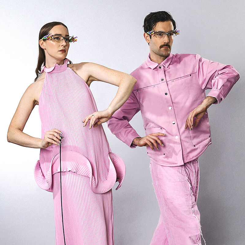 The Young Emperors are in sync in petal pink outfits with matching festive eyeglass frames. 