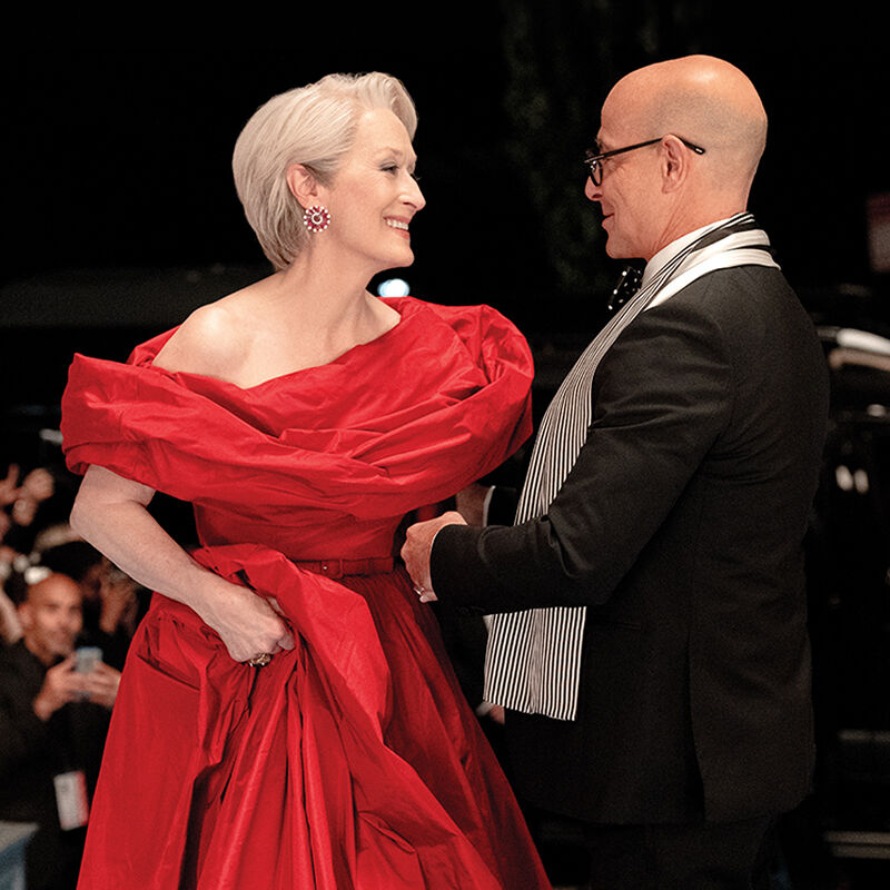 Nigel Kipling, deputy editor of Runway, welcomes his boss Miranda Priestly, the event’s host, and her devilishly glamourous red-hot gown to the cerulean carpet at the annual Runway Gala.