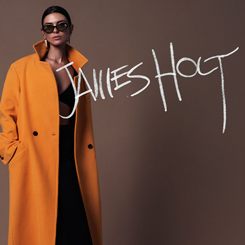 A model sports a floor-length goldenrod bespoke jacket from the new outerwear line JH by designer James Holt.