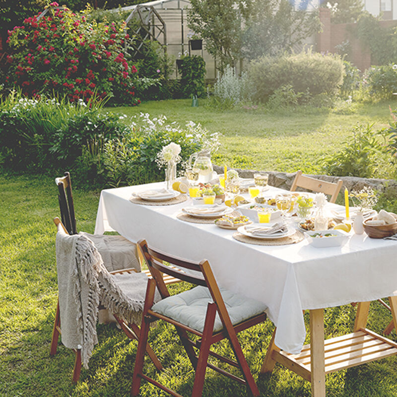 A dining table is set up in the garden for guests as eating alfresco is one of the best summer rituals.