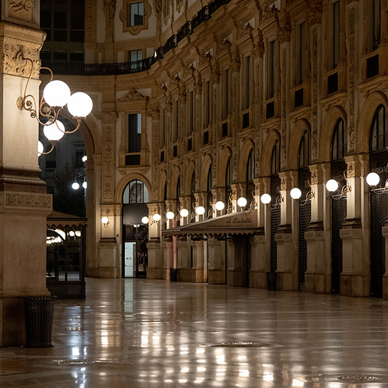 At night, the halls of Milan’s Galleria Vittorio Emanuele II, Italy’s oldest active shopping arcade are quiet and lit by globe scones. But by day, the four-story landmark named after the first king of Italy buzzes with shoppers and sightseers admiring its massive glass dome, mosaic floors and luxury boutiques.