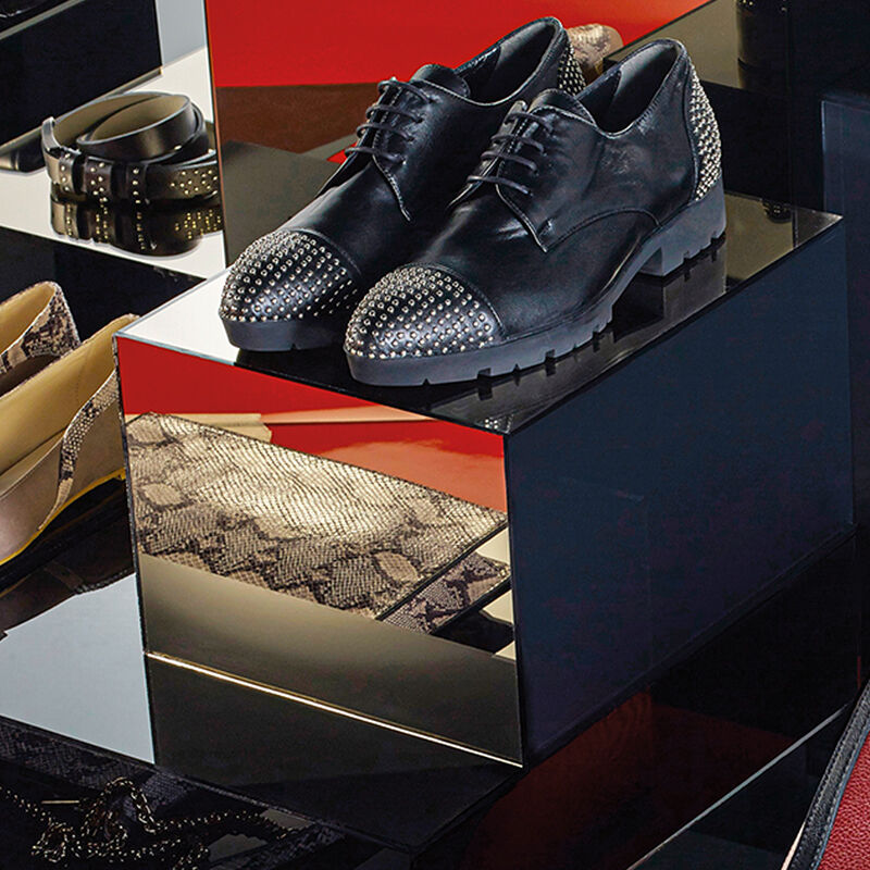 Two models lounge in gray and olive menswear-inspired striped outfits proving that looking professional doesn’t mean dressing plain.