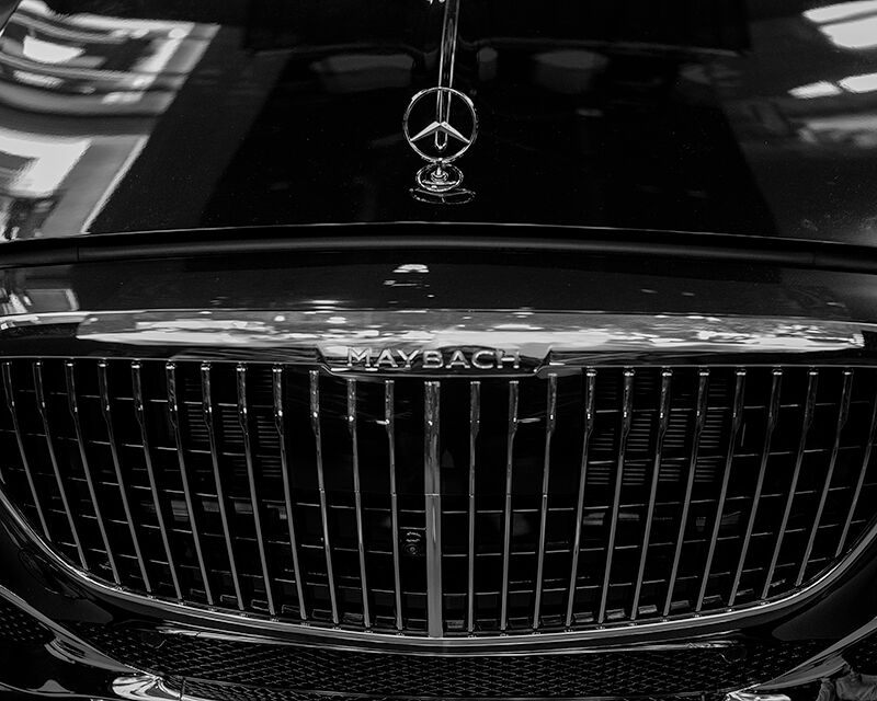 A close-up look at the sleek lines and commanding grill of a silver Mercedes-Maybach S-Class.